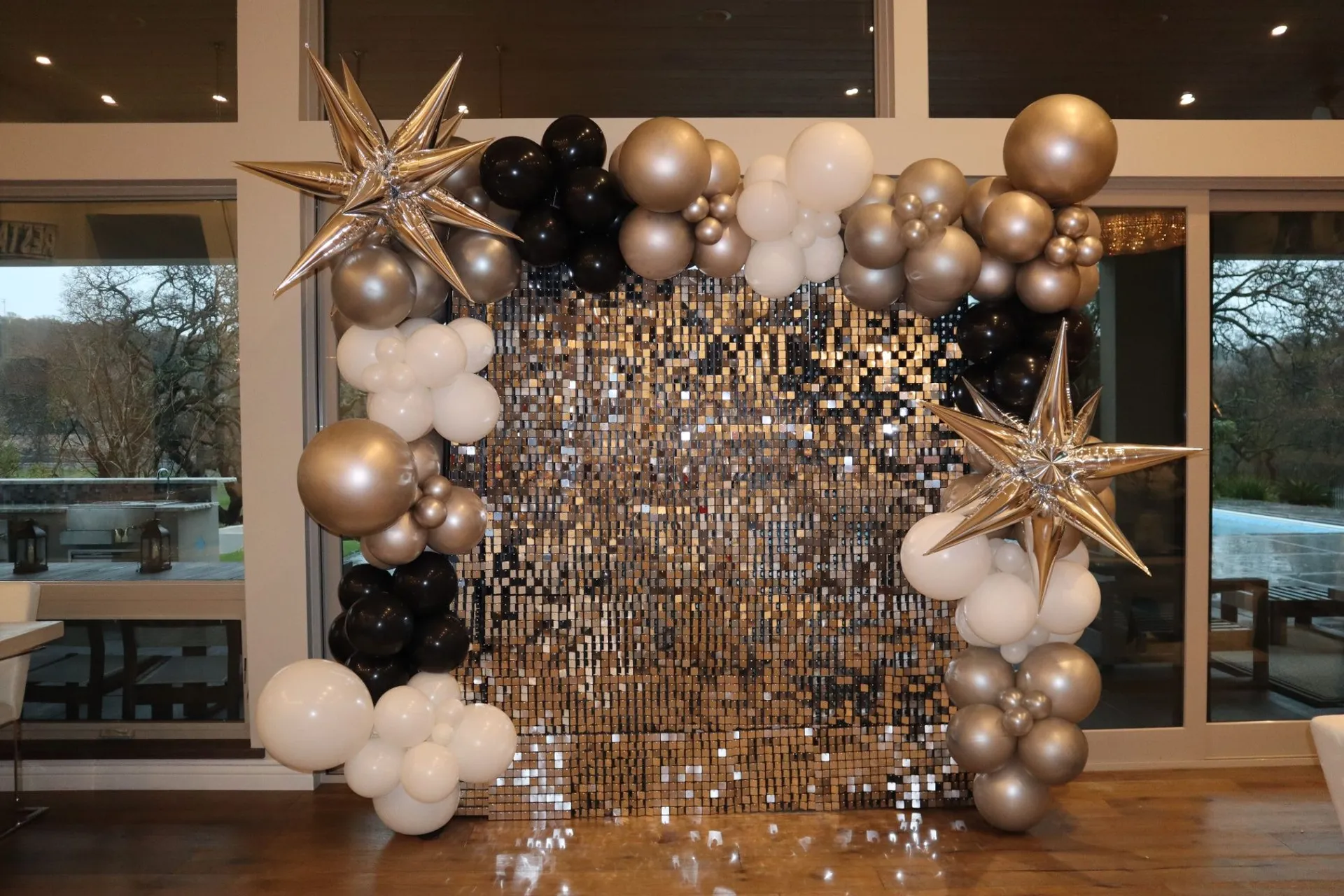 Elegant gold, cream, and black balloon garland framing a shimmer backdrop