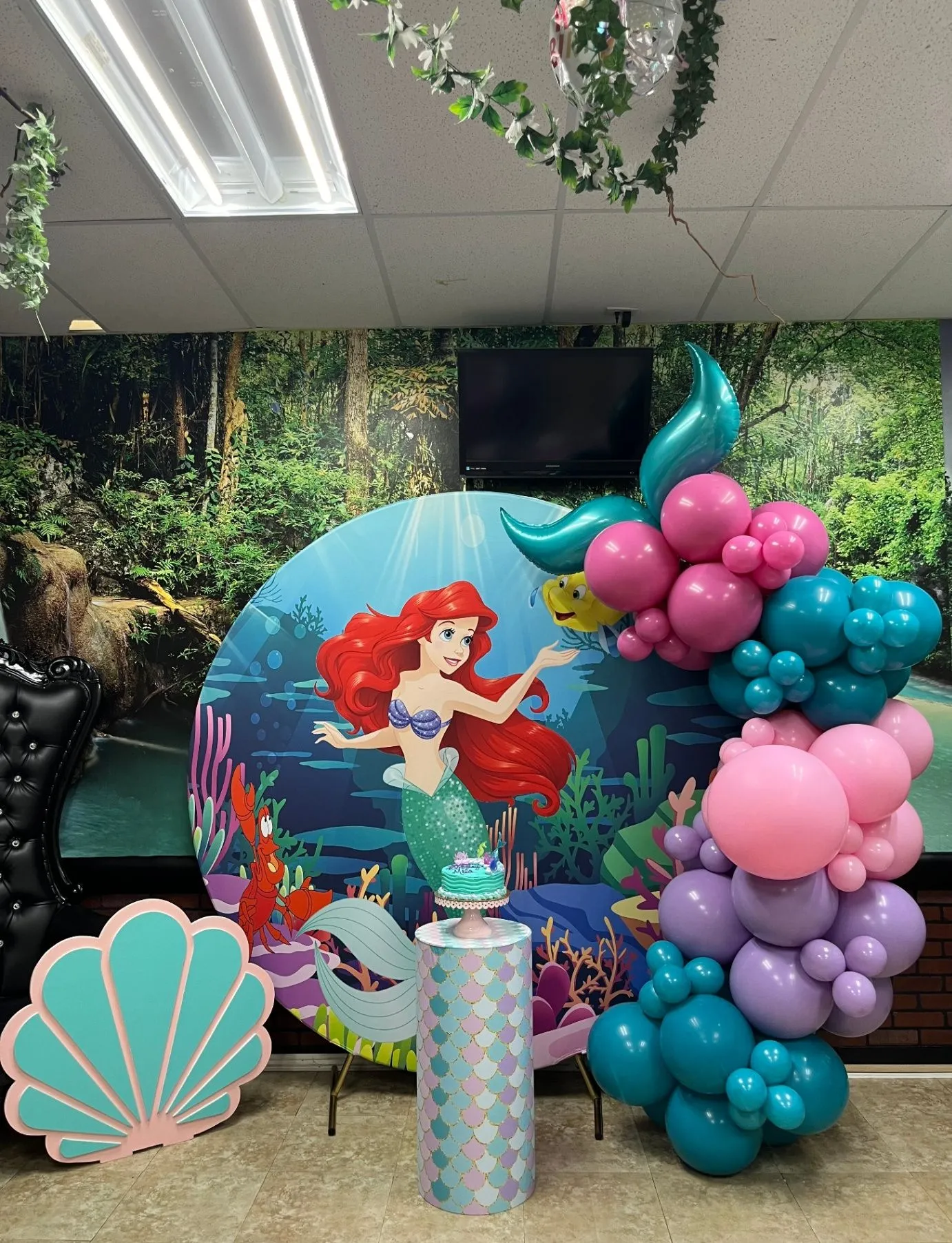 Mermaid party backdrop with a colorful balloon garland and themed decor